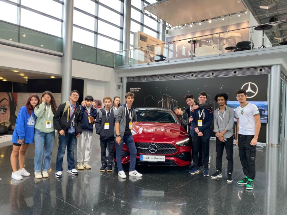 Summer Camp participants stand in front of a car on an excursion