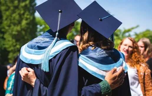 Two Graduated Students Hug – Picture from the Back
