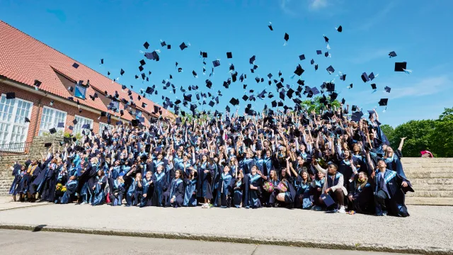 Students celebrating their graduation with the hat toss
